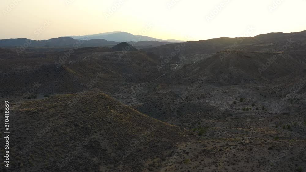 Golden sunset over Tabernas desert and mountains in Almeria, Spain. Drone dolly forward, high angle. Golden sunset over Tabernas desert and mountains in Almeria, Spain. Drone dolly forward, high angle.