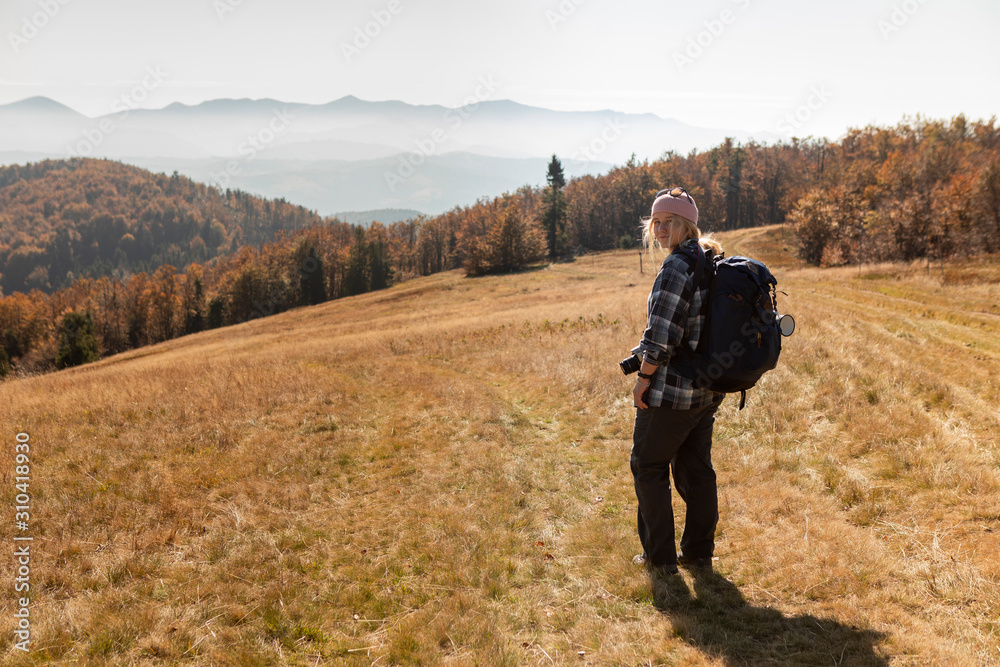 smiling woman in a cap with backpack hiking the mountains smiling woman in a cap with backpack hiking the mountains