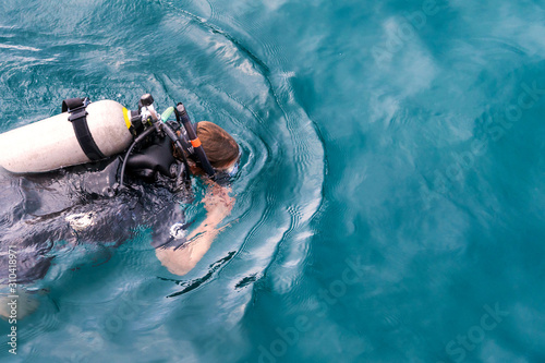 Girl diver floating on the surface of the water.