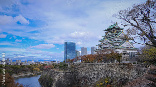 Osaka castle surrounded by the stones’ sheer walls with modern building and blue sky background in autumn season, Osaka City, Kansai, Japan. Castle is one of Japan's most famous landmarks.