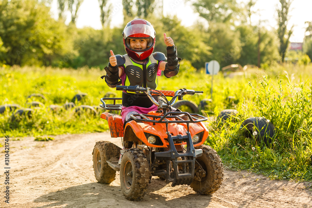 Little girl riding ATV quad bike in race track Little girl riding ATV quad bike in race track
