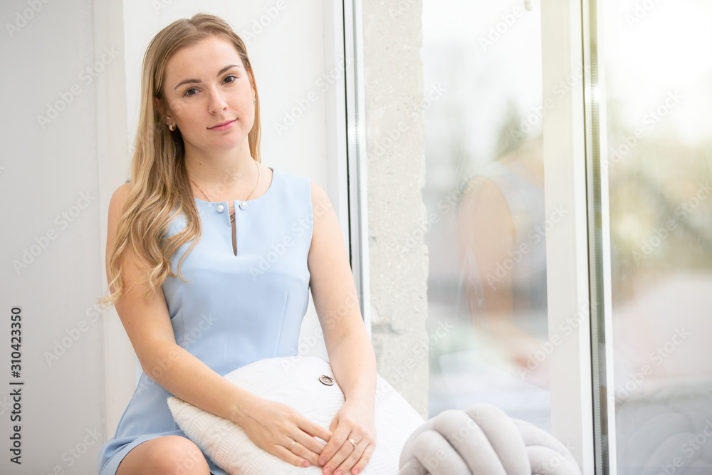 Young ordinary woman at home near the window. Young ordinary woman at home near the window.