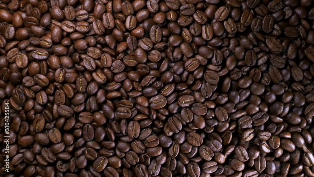 Roasted coffee bean. Fragrant coffee beans scrolls slowly around the camera. Slow Motion Close Up of Whole Roasted Coffee Beans. Roasted coffee bean. Fragrant coffee beans scrolls slowly around the camera. Slow Motion Close Up of Whole Roasted Coffee Beans.
