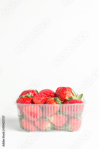 Natural red strawberries in a plastic transparent container