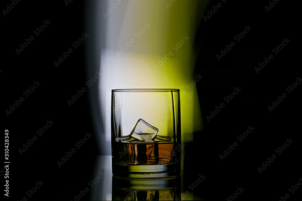 glass of whiskey in spotlight background