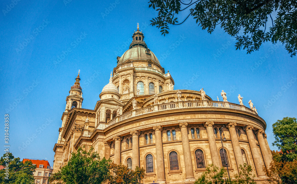 Budapest, Hungary - July 14, 2019: majestic facade of the old St. Stephen's Basilica in Budapest and crowd of tourists on the street, Hungary. Great Catholic Cathedral, built in the Baroque style. Bud