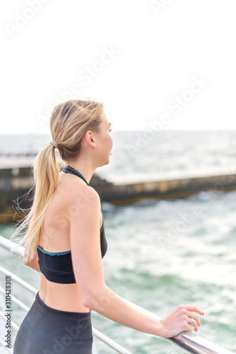 Attractive young girl with long hair in sportswear looking to the sea © iwavephoto