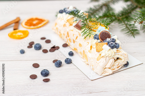 Christmas meringue roll with lemon, blueberry and chocolate