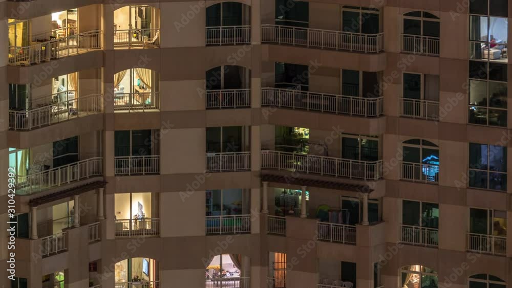 Glowing windows of the multi-storey building with lighting inside and moving people in apartments timelapse. Aerial view of modern residential skyscrapers in Dubai greens district Glowing windows of the multi-storey building with lighting inside and moving people in apartments timelapse. Aerial view of modern residential skyscrapers in Dubai greens district