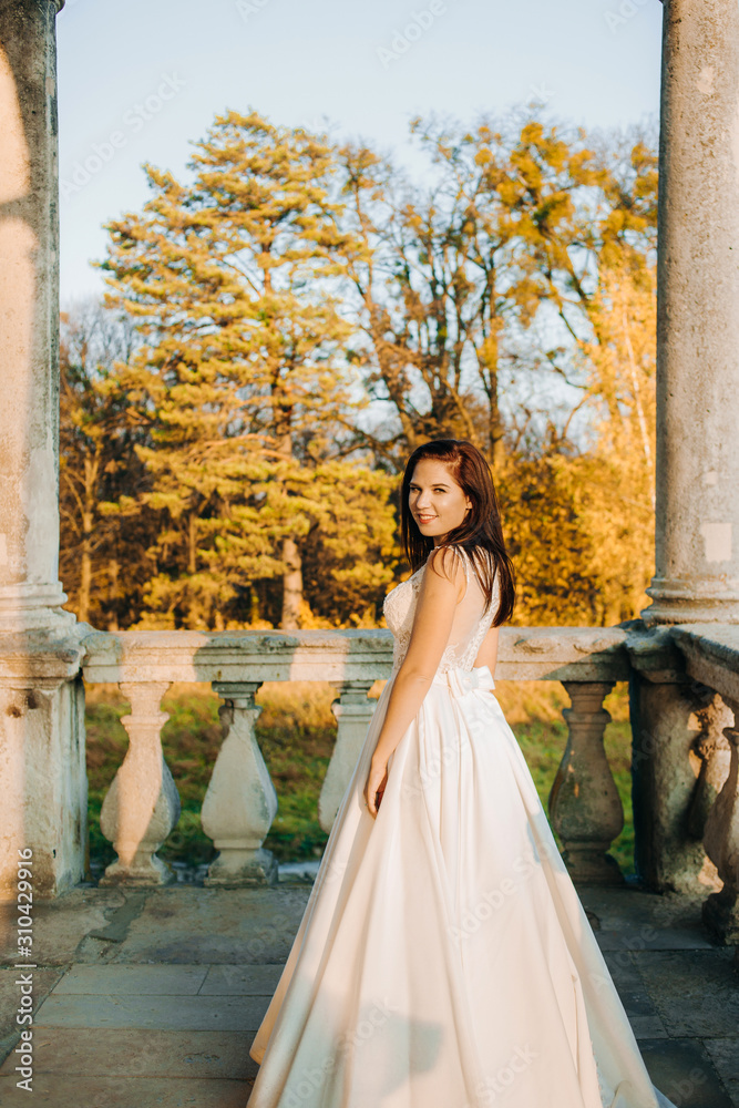 Obraz premium Pretty redheaded bride stands on the balcony of an old castle