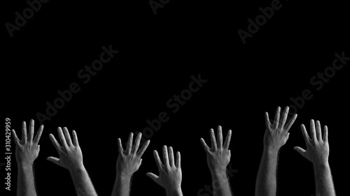 Many male hands stretching to the top. Stretching hands on a black background.