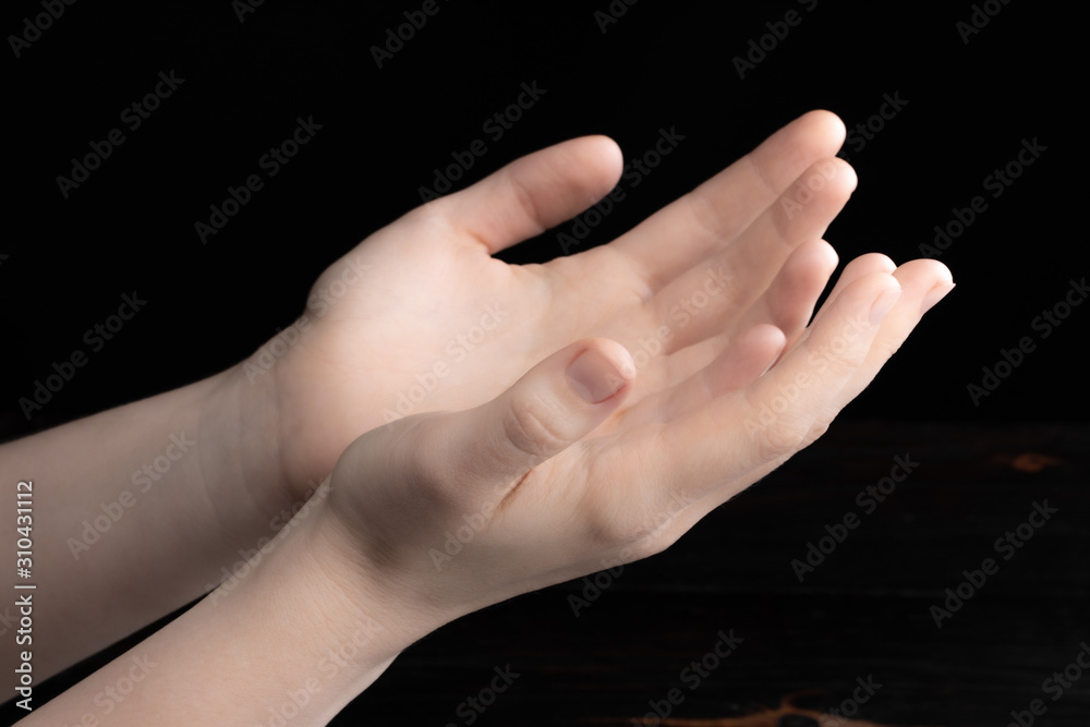 Fototapeta premium Praying hands is in the dark with light on the hands
