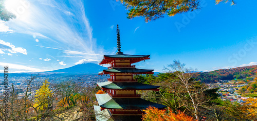 Beautiful view from Chureito Pagoda in Autumn season with mountain Fuji wearing hat in the background. Fujiyoshida, Japan. photo