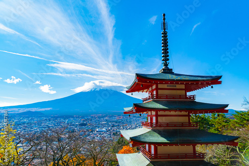 Beautiful view from Chureito Pagoda in Autumn season with mountain Fuji wearing hat in the background. Fujiyoshida  Japan.