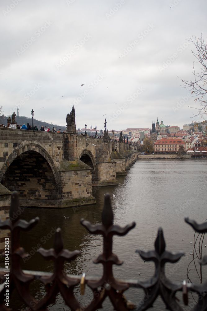 Obraz premium The main attraction of the Czech capital city of Prague is the Charles Bridge on Christmas Eve with many tourists and a view of the Vltava River.