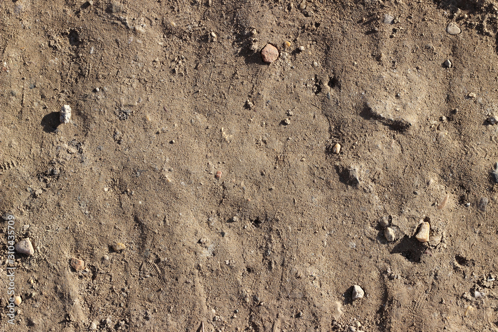 Dirt road surface with stones, dry soil, close up, top down Dirt road surface with stones, dry soil, close up, top down