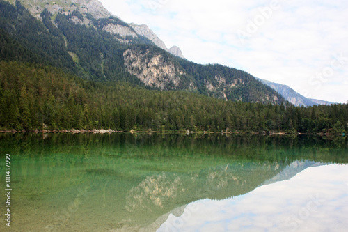 Mountains reflected in green water