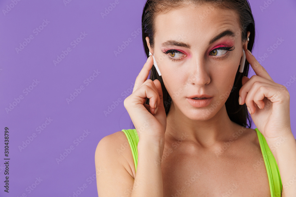 Photo of cute confused woman using earpods and looking aside Photo of cute confused woman using earpods and looking aside