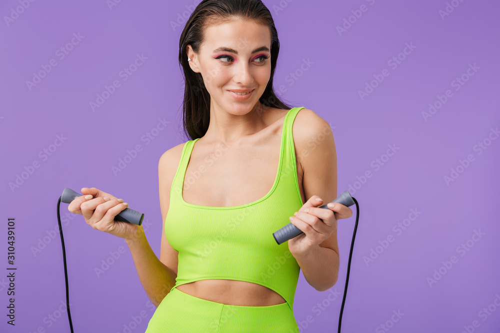 Photo of young happy woman doing exercise with jump rope and smiling Photo of young happy woman doing exercise with jump rope and smiling
