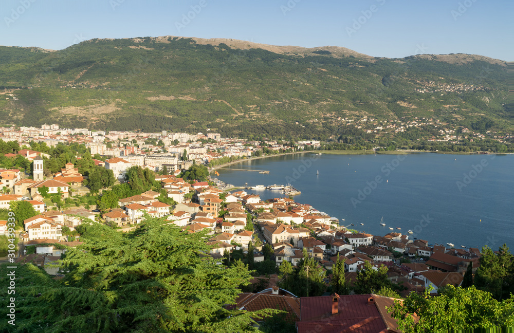 Ohrid and Ohrid Lake on a sunny summer day, view from above from castle hill, mountains and the blue sky in background. Ohrid and Lake Ohrid are Cultural and Natural World Heritage Sites by UNESCO.