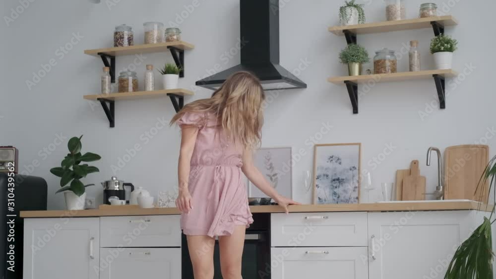 funny girl dancing funny in the kitchen. young woman is spinning home funny girl dancing funny in the kitchen. young woman is spinning home
