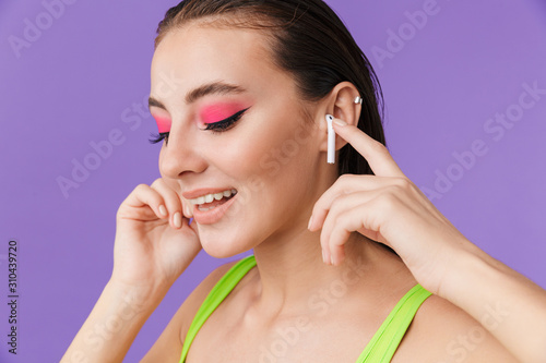 Photo of cute happy woman using earpods and smling photo