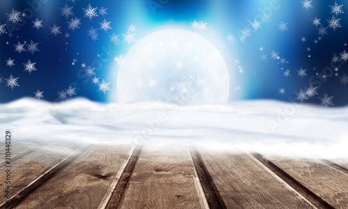 Winter background. Winter snow landscape with wooden table in front. Dark winter forest background at night. Snow, fog, moonlight. Dark neon night background in the forest with moonlight. © MiaStendal