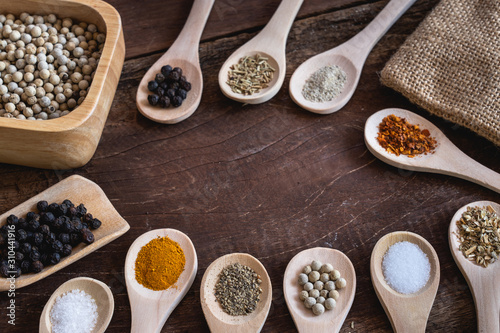 Various spices in wooden spoon on wood table background