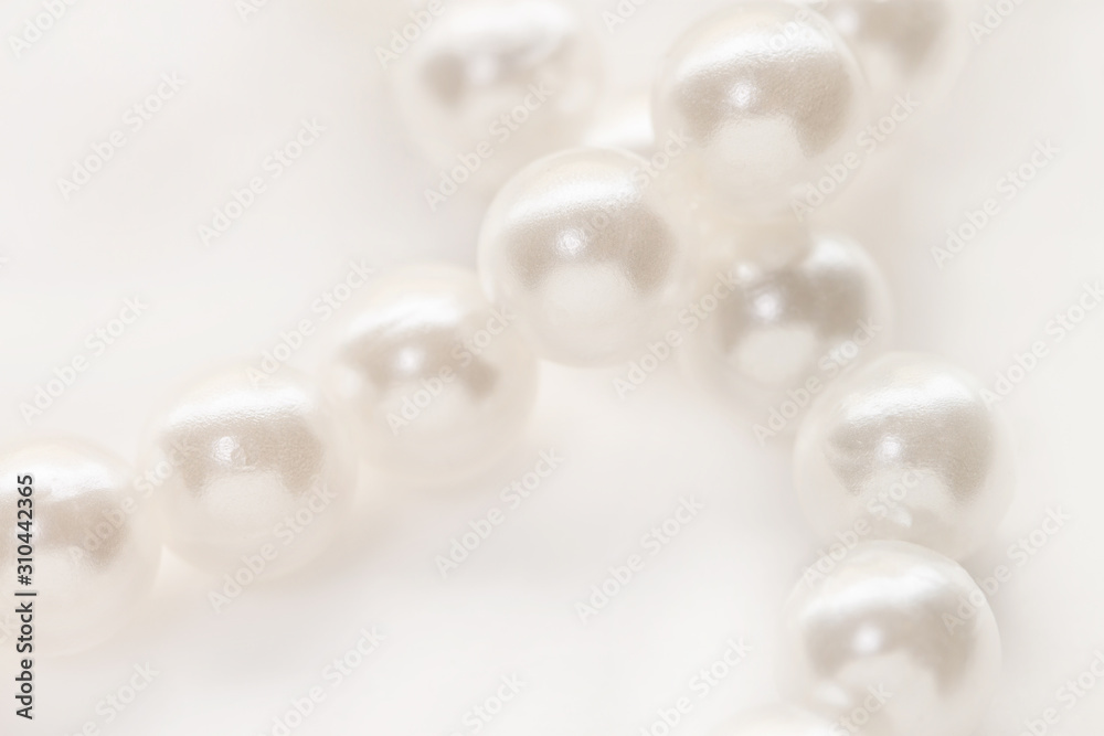 Necklace with shining white pearl criss cross isolated background macro Necklace with shining white pearl criss cross isolated background macro