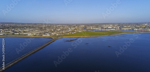 Aerial view on causeway from Mutton island to Galway city, Panorama image, South Park, Claddagh and city center and port in the background. Sunny day.