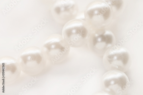 Necklace with shining white pearl criss cross isolated background macro