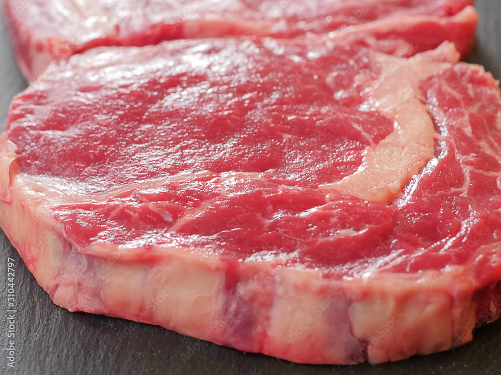 Two fresh uncooked raw beef rib eye steaks, Selective focus. Close up. Two fresh uncooked raw beef rib eye steaks, Selective focus. Close up.
