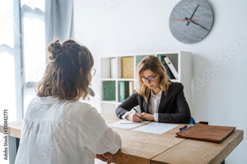 Young female candidate interviewed by employer photo