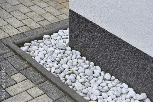 Pebbles for drainage of water along the house next to the wall. Rainwater harvesting photo