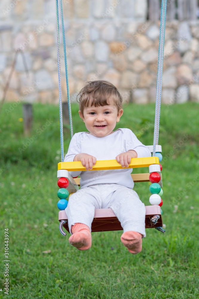 Happy beautiful child on swing
