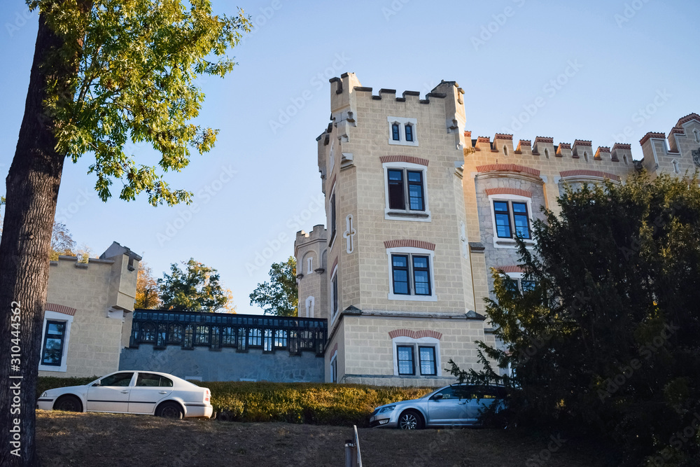 Tower of an old castle in a European city and cars on the road