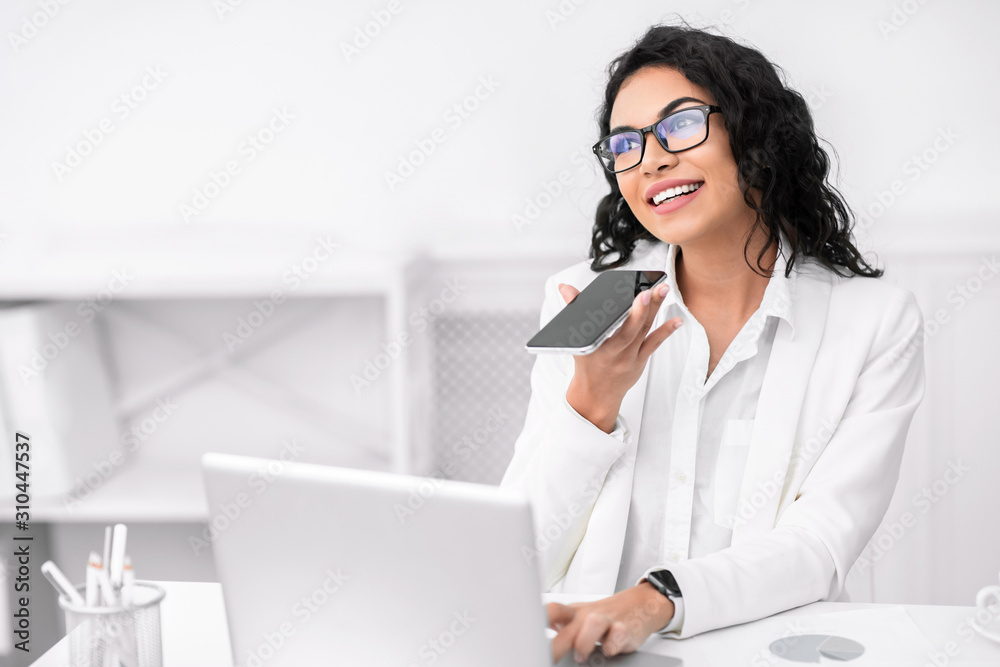 Pensive mexican woman using voice assistant on cellphone Pensive mexican woman using voice assistant on cellphone