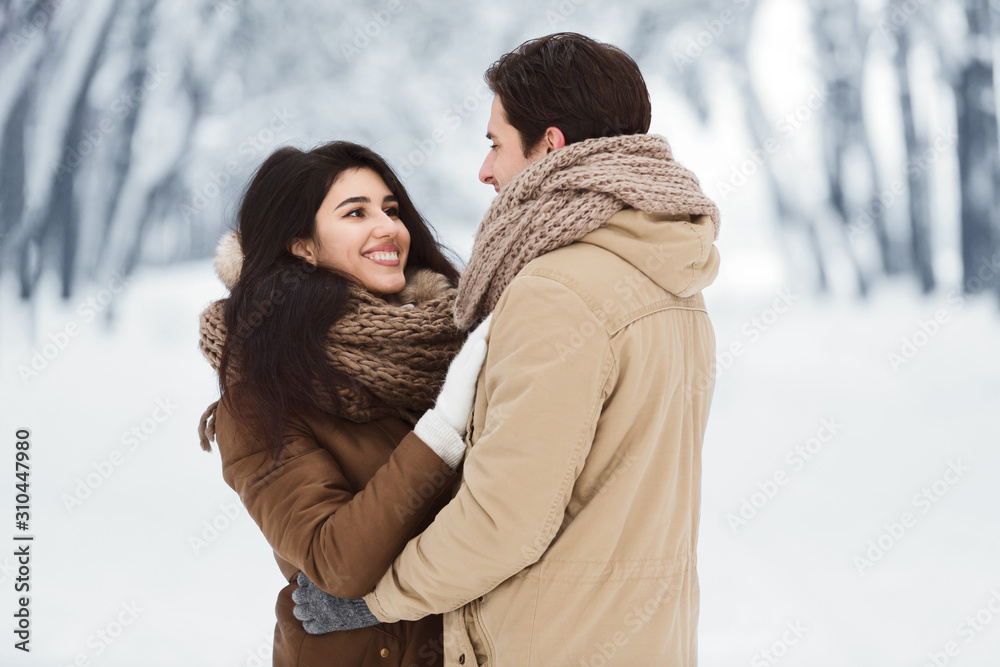 Loving Husband And Wife Hugging Standing In Snowy Park Loving Husband And Wife Hugging Standing In Snowy Park