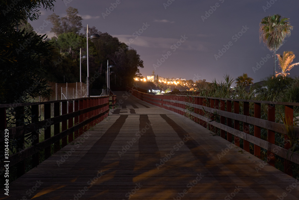 Obraz premium Marbella promenade at night with wood path