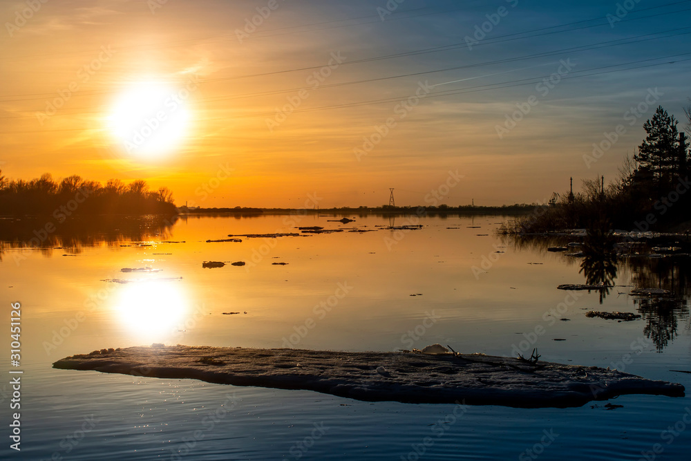 Obraz premium Ice on the river during the ice drift lit by the setting sun in the spring.