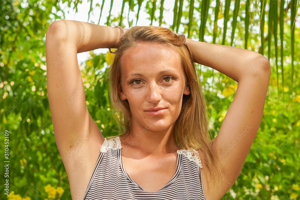 The girl posing in the tropical garden with palms The girl posing in the tropical garden with palms