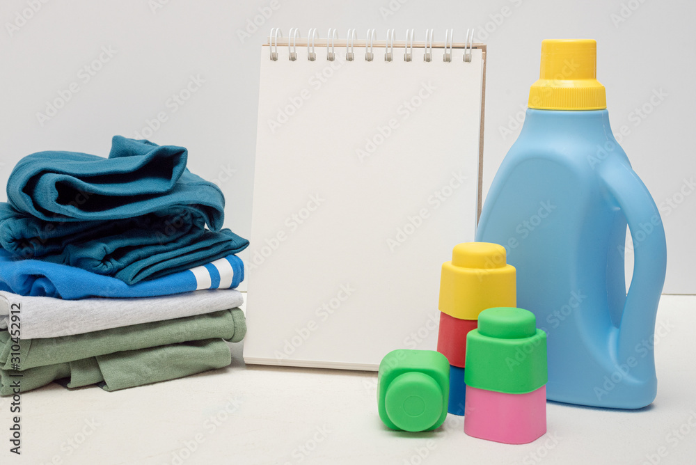 Laundry tips mock up. Detergent bottle and blank page notepad with copy space on white background. Laundry tips mock up. Detergent bottle and blank page notepad with copy space on white background.