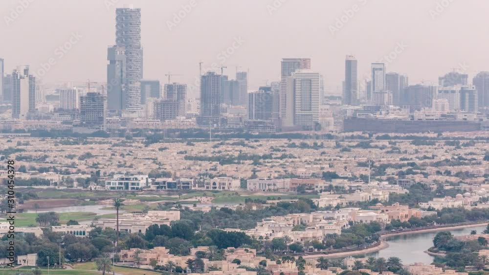 Aerial view of apartment houses and villas in Dubai city timelapse near jumeirah lake towers district, United Arab Emirates. Towers and construction site on a background. Top fiew from skyscraper Aerial view of apartment houses and villas in Dubai city timelapse near jumeirah lake towers district, United Arab Emirates. Towers and construction site on a background. Top fiew from skyscraper