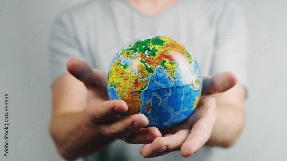 World Environment Day. Global warming and plastic emissions. Male hand holds planet earth ball. The globe with geographical names in Ukrainian cyrillic. Letters on it in polyethylene. Zero waste World Environment Day. Global warming and plastic emissions. Male hand holds planet earth ball. The globe with geographical names in Ukrainian cyrillic. Letters on it in polyethylene. Zero waste