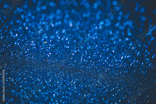 Blue abstract bokeh background. Blue Christmas texture. Defocused shiny sequins.