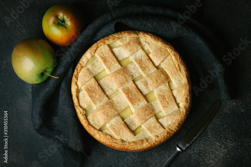 Homemade fresh baked rustic apple pie on dark background
