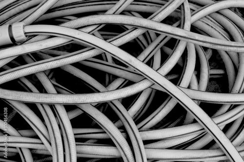 Yellow pile of a tangled long hose or cable wire background texture in black and white