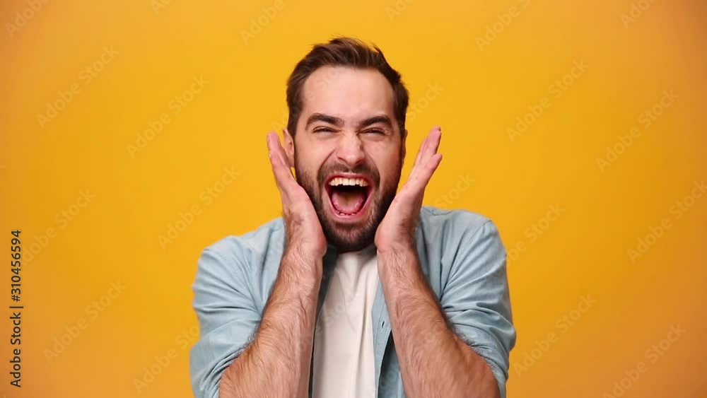 Handsome unshaven bearded young guy 20s in denim shirt white t-shirt isolated over yellow background in studio. People sincere emotions, lifestyle concept. Looking at camera scream rejoice win happy Handsome unshaven bearded young guy 20s in denim shirt white t-shirt isolated over yellow background in studio. People sincere emotions, lifestyle concept. Looking at camera scream rejoice win happy