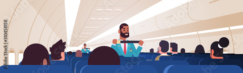 steward explaining passengers how to use seat belt fastening in emergency situation african american flight attendants in uniform safety demonstration concept airplane board interior horizontal vector
