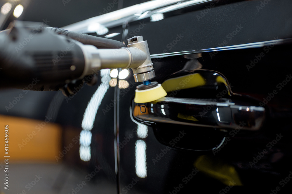 Car service worker polishing vehicle door handle with special wax from scratches, close-up. Professional car detailing and maintenance concept Car service worker polishing vehicle door handle with special wax from scratches, close-up. Professional car detailing and maintenance concept
